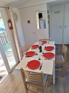 鲁西隆地区卡内Mobile home Chic的一张餐桌,上面有红色的盘子