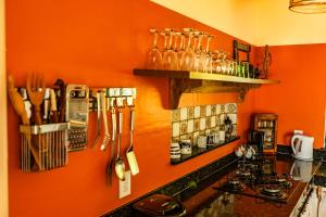 桑塔克鲁茨卡巴利亚Casa Papaya的厨房设有橙色墙壁和带餐具的柜台。