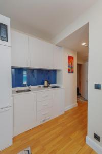 巴统Orbi City Luxury Towers的空厨房,配有白色橱柜和蓝色的墙壁