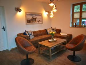 博恩Boddenkutter的客厅配有棕色沙发和两把椅子