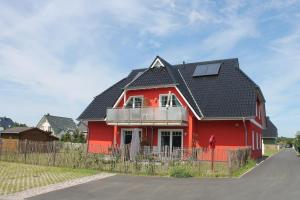 博恩Ferienwohnung Ocean in Born的黑色屋顶的红色房子