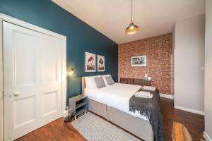 布莱尔高里Central Apartment - Industrial的一间卧室设有一张床和砖墙