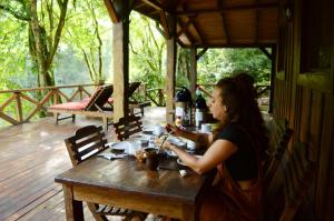 埃尔索韦维奥Margay - Reserva Natural y Lodge de Selva的坐在甲板上木桌旁的女人
