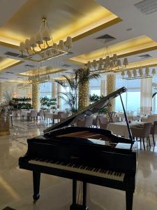 敖德萨卡多尔度假酒店的配有桌椅的房间的钢琴