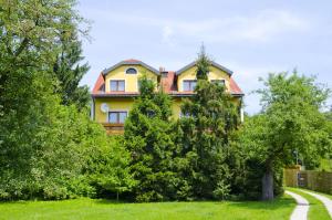 盖布利茨罗斯纳酒店的前面有树木的黄色房子