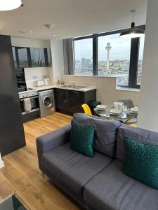 利物浦Stunning City View Apartment by Central Stay的带沙发和桌子的客厅以及厨房。