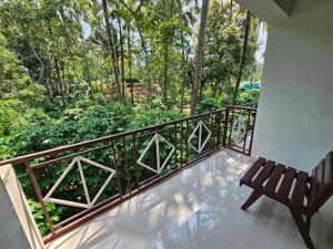 提喀迪Pknhomestay kumily thekkady的阳台设有长凳,享有树林美景。