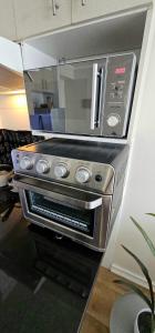 圣地亚哥moderno, acogedor departamento Vitacura Las Condes的厨房里配有不锈钢烤箱及微波炉