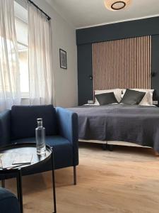 佩奇Central Studio的一间卧室配有一张床、一张蓝色的沙发和一张桌子