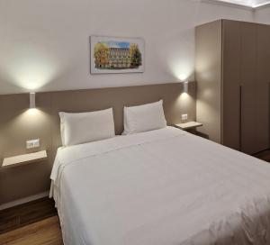 都灵罗马和凯沃尔岩酒店的卧室配有一张带两个枕头的大白色床