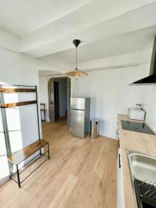 马诺斯克Appartement ensoleillé Manosque的客房设有一间铺有木地板的厨房。