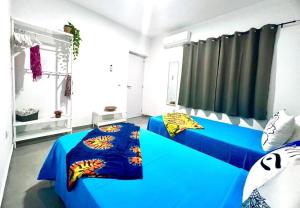 圣玛丽亚Animos! Apartments - 10 modern apartments near the city & beach, perfect for nomads, travellers, families, watersports!的一间卧室设有蓝色的床和窗户。