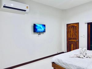 Ban Ko KokSisters Home ที่พักใกล้สวนพฤกษศาสตร์ ระยองแหลมแม่พิมพ์的卧室配有一张床,墙上配有电视。