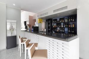 马托西纽什Hotel Amadeos - Matosinhos - Porto的酒吧设有凳子和酒瓶