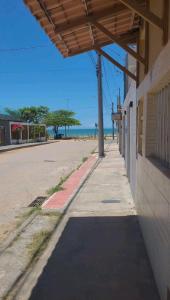 瓜拉派瑞Pousada Dule的一条空的街道,毗邻一座有海洋的建筑