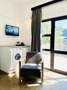 约翰内斯堡JHB City Living 119 - fibre Wi-Fi, washing machine & big sunny balcony的客厅配有洗衣机和椅子