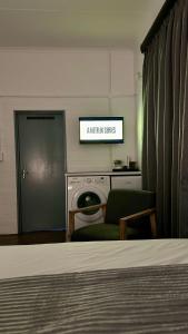 约翰内斯堡JHB City Living 119 - fibre Wi-Fi, washing machine & big sunny balcony的客厅,配有床和可读厨房换档的标志