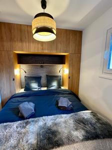 圣埃蒂安德蒂内埃Ecrin Alpin hyper centre d'Auron的一间卧室配有一张带蓝色棉被的大床