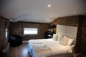 利物浦里士满德公寓的一间卧室设有一张大床和砖墙
