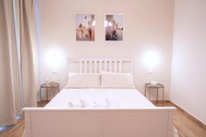 蒂沃利La Bifora的墙上有两张照片的房间的一张白色床