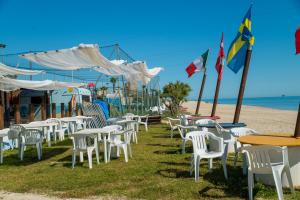 利多迪费尔莫Residence Baiadosol的沙滩上摆放着一束桌椅