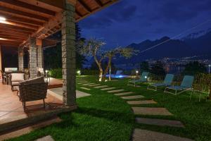 奥利维托拉里奥Villa Vittoria with private seasonal heated pool & shared sauna - Bellagio Village Residence的庭院在晚上的草坪上摆放着椅子