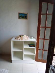 卡拉瓜塔图巴Suíte em Caraguá的一只狗躺在白色书架上