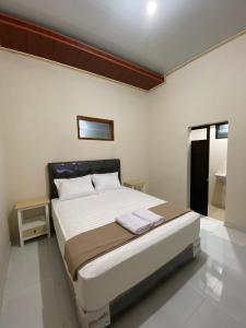 KalasanNawasena Guesthouse Jogja的一间卧室,卧室内配有一张大床