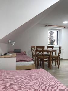 莫德拉瓦Apartmány v Chalupě nad Modravou的一间卧室配有一张床和一张桌子及椅子