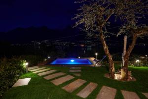 奥利维托拉里奥Villa Vittoria with private seasonal heated pool & shared sauna - Bellagio Village Residence的夜间在院子中间的游泳池