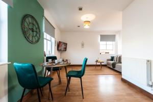 南安普敦Prime Location 1-bedroom apartment - Close to Solent-Hospital-Amazon Voucher for long stay的客厅配有桌椅和时钟