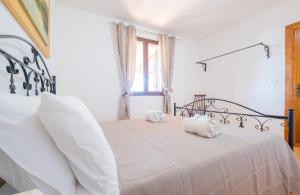 斯佩基亚Villa Giulia con Piscina Privata - Specchia的白色卧室配有带两个枕头的床
