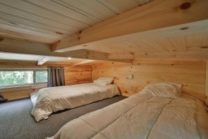 查塔努加Ryon Tiny Home Cabin City-side Rustic Retreat的小木屋内一间卧室,配有两张床