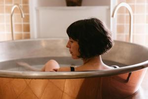 马盖特No 42 by GuestHouse, Margate的坐在金属浴缸中的女人