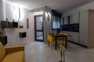 米兰La casa sul Naviglio的厨房以及带桌子和黄色椅子的用餐室。