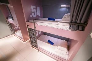 哥打京那巴鲁Homy Seafront Hostel的粉红色墙壁的客房内设有两张双层床。