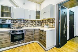 巴库Apartment Armani Lux的厨房配有白色橱柜和黑色冰箱。