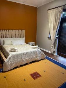 GqeberhaFun-filled, cosy family home的卧室配有一张铺在地板上的地毯。