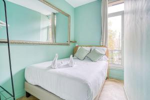 巴黎Appartement proche Parc Monceau #ArcDeTriomphe-II的一间卧室配有一张带镜子的床和窗户