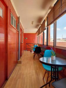 卡尔德拉Hostal Jardín del Desierto的走廊上设有桌椅,房间设有红色的墙壁