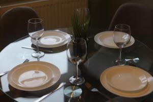 伊普斯威奇Shamrock House- 2 BR House, Free Parking & WIFI的一张桌子上放有盘子和酒杯