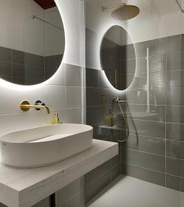 拉奎拉Ginevra Boutique Rooms - Palazzo Leosini - Residenze D'Epoca的一间带水槽和两面镜子的浴室