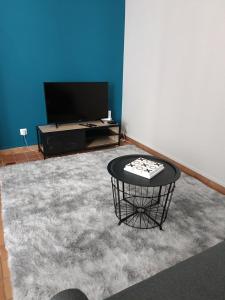 洛什Magnifique appartement hyper centre de Loches的客厅配有桌子和电视