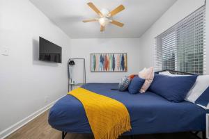 伯明翰Vulcan’s Hideout / Colorful C2的一间卧室配有一张蓝色的床和吊扇