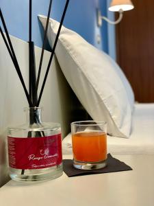 里米尼Hotel Alfa ALL INCLUSIVE 2024的瓶子里的饮料,放在桌子上的花瓶边