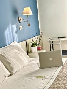 里米尼Hotel Alfa ALL INCLUSIVE 2024的床上的笔记本电脑