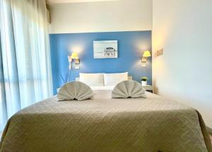 里米尼Hotel Alfa ALL INCLUSIVE 2024的一间卧室配有一张带两个枕头的床