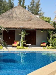 NianingCASA COCO II的小屋前设有游泳池的度假胜地