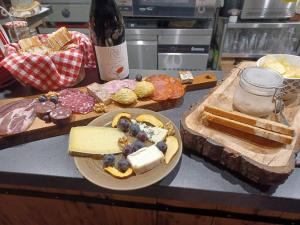 圣皮尔蒂斯查Chambres d hôtes Le clos des vins d anges的一张桌子,上面放着一盘奶酪和一瓶葡萄酒