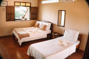 新艾朗Amazônia ParkSuítes的酒店客房设有两张床和窗户。
